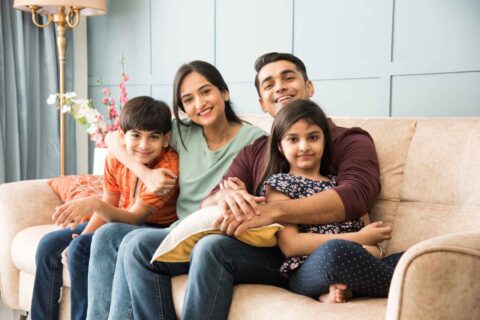portrait-happy-indian-asian-young-family-while-sitting-sofa-lying-floor-sitting-against-wall (1)